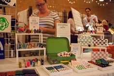 a woman standing in front of a table filled with cards and magnets on it