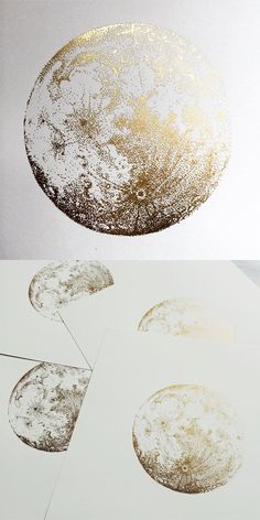 an abstract painting with gold paint on white paper and some circles in the air above it