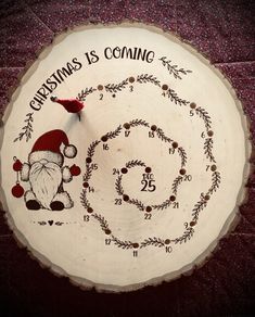 a christmas themed wooden clock with santa claus's is coming on the clock face