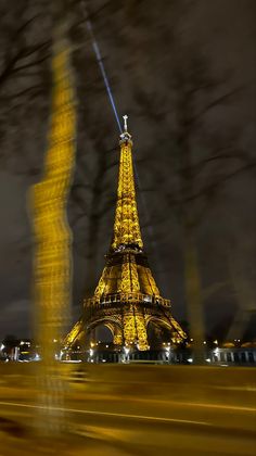 the eiffel tower is lit up at night