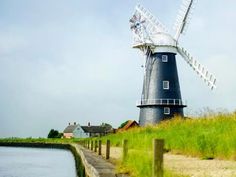 a windmill sitting next to a body of water