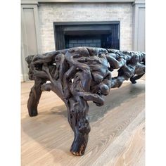 a wooden bench sitting on top of a hard wood floor next to a fire place