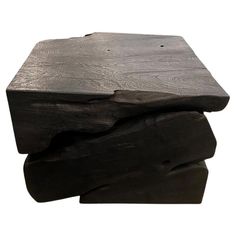 three pieces of black wood stacked on top of each other with one piece missing from it