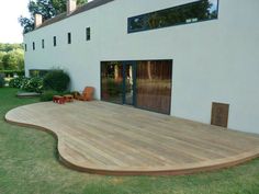 a large wooden deck in front of a house with sliding glass doors on the side