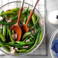 a glass bowl filled with green beans and radishes