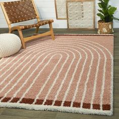 a large rug with brown and white stripes on the floor in front of a chair