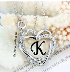 a heart shaped initial necklace with the letter k in it's center on a chain