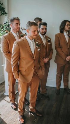 a group of men in suits standing next to each other on a hard wood floor