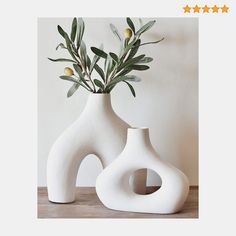 two white vases sitting on top of a wooden table