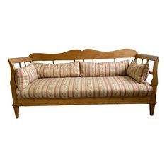 an old wooden couch with pillows on it's back and arm rests against a white background