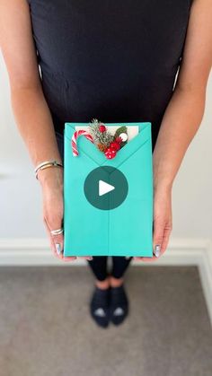 a woman is holding an envelope with candy canes and candies in the center