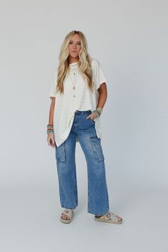 Elevate your casual boho style with our Britain Cargo Jeans - with their trendy wide legs and comfortable fit, you'll feel stylish and confident in any setting! Comfortable denim fabric with a nice fade on the thighs for a worn look Relaxed, wide leg, cargo style pant silhouette High - rise waist with a button - zipper closure and belt loops Convenient side pockets and double patch flap cargo pockets along the side and back Pair with: High Neck Racerback Brami, On The Fringe Kimono and Color Bur Wide Leg Cotton Cargo Jeans With Frayed Hem, Spring Full-length Cargo Jeans With Multiple Pockets, Casual Mid-rise Cargo Jeans With Frayed Hem, Spring Wide-leg Cargo Jeans With Frayed Hem, Cotton Ankle-length Cargo Jeans, Casual Boho Style, Boho Essentials, Bralette Outfit, Cargo Jeans