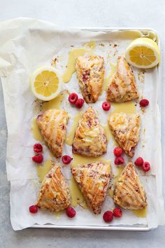 lemon and raspberry scones on parchment paper with drizzled icing