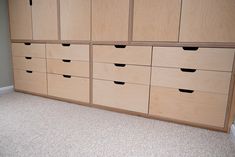 an empty room with many drawers and carpeted flooring on the floor, in front of a white wall