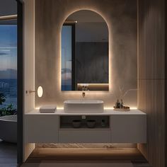 a bathroom with an oval mirror above the sink and lights on the wall behind it