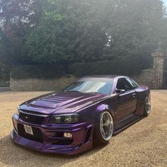 the purple car is parked in front of some trees