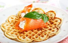 a white plate topped with waffles covered in salmon