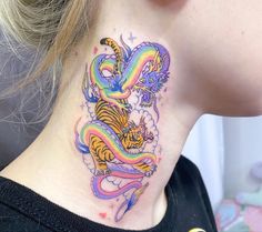 a woman's neck with a colorful dragon tattoo on her left side ribcage