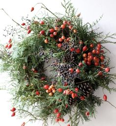 a christmas wreath with berries and pine cones