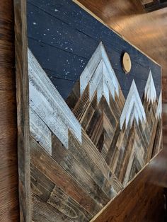 a wood panel with mountains painted on it