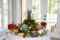 a white table topped with lots of fruit and veggies on top of it