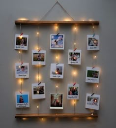 a wooden frame with pictures hanging on it and string lights strung from the wall behind it