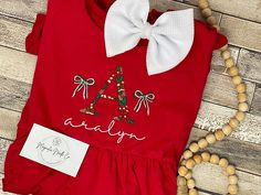 "Christmas dress, embroidered Christmas shirt,Christmas shirt, girls Christmas dress, custom embroidered dress, personalized Christmas outfit custome embroidered Christmas outfit! this can be done on a variety of outfit blanks!  There are various color combos and patterns available! THESE TAKE AROUD A WEEK TO SHIP we are ordering this as needed past one of each size on hand so I want to make sure to set expectations appropriately :) These are USA standard \"snug fitting, flame resistant\" Hey y'all,  First of all, thank you and welcome to our shop! Hi, Thank you so much for your business and support of our passion to create custom items for you! Please know it is our goal to give you the best quality and service we can!  IF YOU NEED THIS SHIPPED OUT in a hurry PLEASE ADD THE RUSHED ORDER F Fitted Cotton Christmas Holiday Dress, Fitted Cotton Christmas Dress, Fitted Cotton Holiday Dress For Christmas, Embroidered Holiday Dresses For Festive Occasions, Embroidered Dresses For Festive Holiday, Short Sleeve Cotton Christmas Dress, Red Embroidered Christmas Dress, Festive Cotton Holiday Dress For Christmas, Festive Cotton Holiday Dress