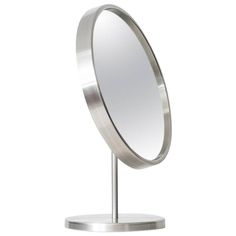 a round mirror on a metal stand with a circular mirror in the middle and one side