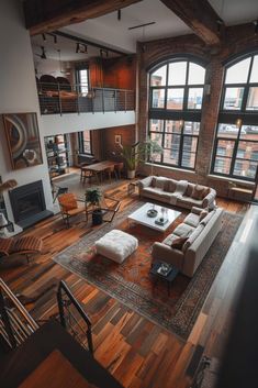 a living room filled with lots of furniture next to large windows on top of a wooden floor