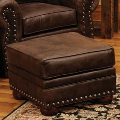 a brown leather chair and ottoman in a living room