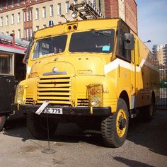 a large yellow truck parked next to a building