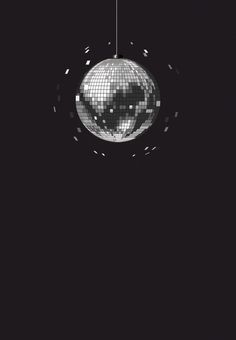 a disco ball hanging from the ceiling in front of a black background with white dots