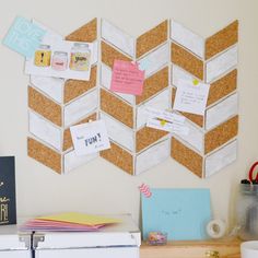 a cork board with notes pinned to it on the wall next to a file cabinet