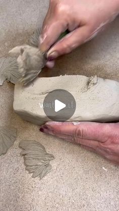 someone is using clay to make a bird sculpture on the ground with their hands and feet