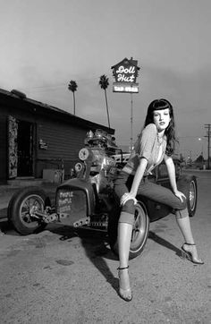 a woman sitting on top of an old car