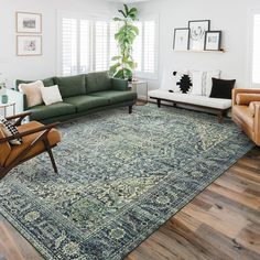 a living room filled with furniture and a large rug on top of a hard wood floor