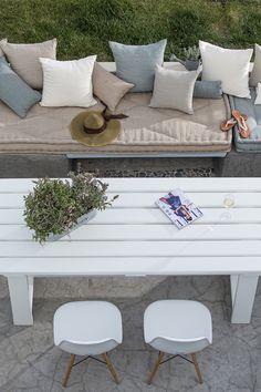 a white table sitting next to a couch covered in pillows