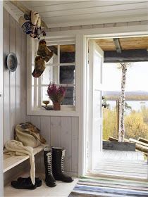 there is a bench and some boots on the floor in front of an open door