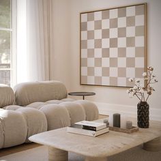 a living room filled with furniture and a checkerboard wall hanging above the couch