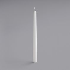 a single white candle on a gray background