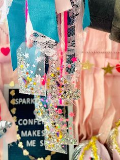 some pink and gold decorations hanging from strings