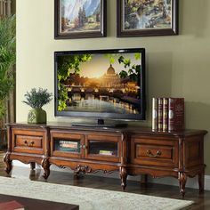 a living room scene with focus on the tv and two framed pictures over the entertainment center