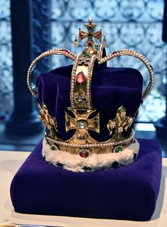 a crown sits on top of a purple cushion