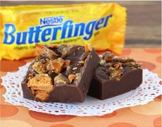 two pieces of peanut butterfingers sitting on a doily next to a bag of candy