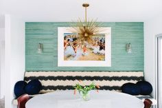 a dining room table with chairs and a painting on the wall