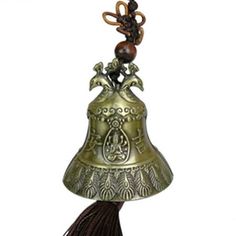 a brass bell with an ornate design on the top and tassels hanging from it