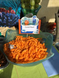 there is a bowl full of carrots and other food on the table with coral reef sign