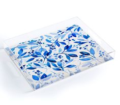 a blue and white floral design glass tray on a white surface with an acrylic edge