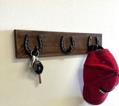 a hat is hanging on a coat rack with two keys and a baseball cap attached to it