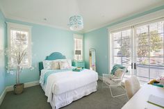 a bedroom with blue walls and white furniture